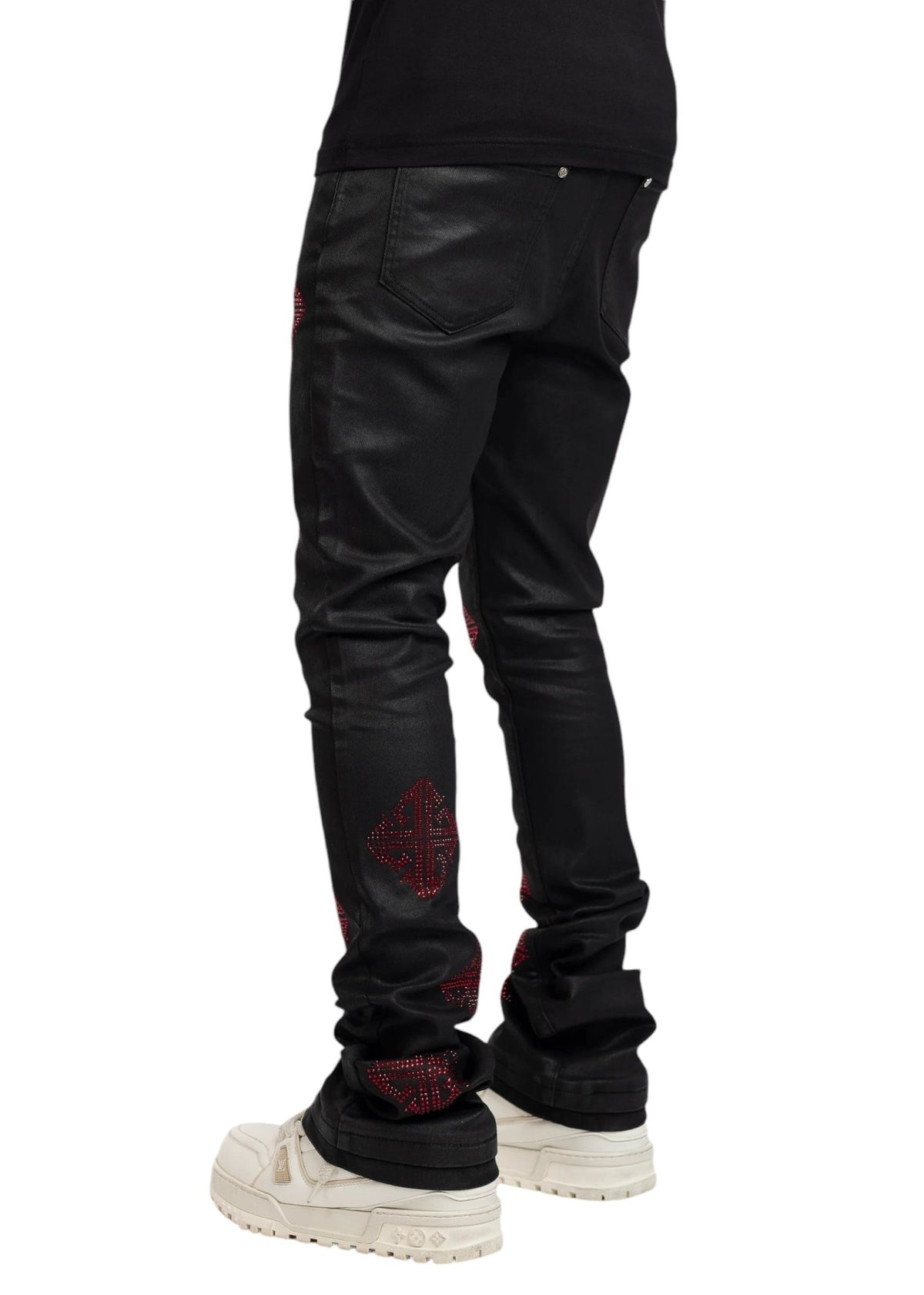 Wearing GUAPI's limited edition Guapi Obsidian Black Icon Embellished Denim V2 with red accents and white sneakers, viewed from the back.