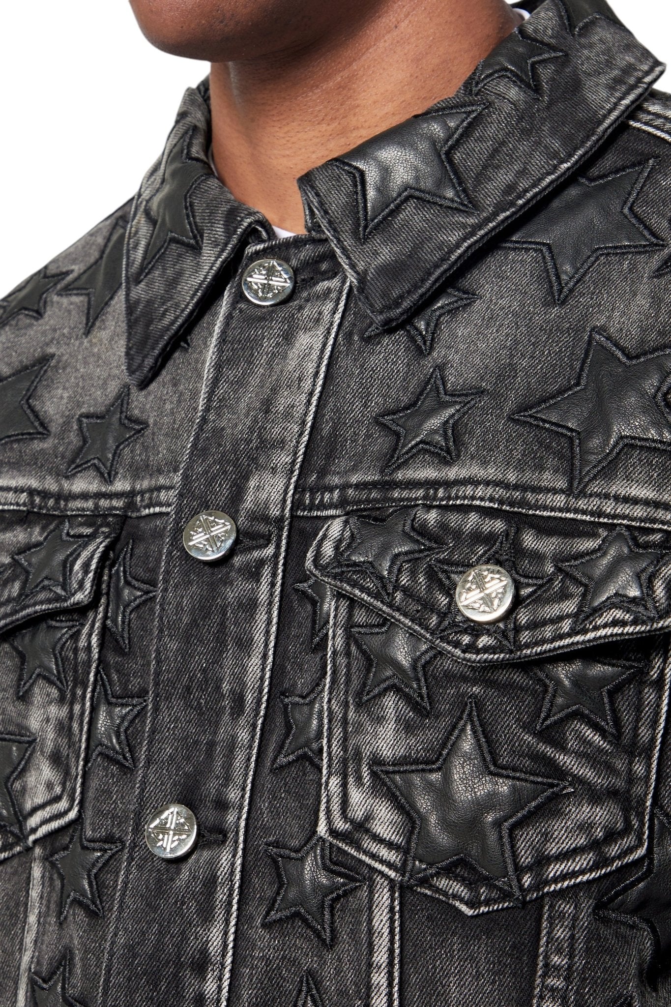 Close-up of the GUAPI Obsidian Black Stars Denim Jacket, highlighting embossed star patterns and metallic buttons—a stylish addition to any streetwear look.