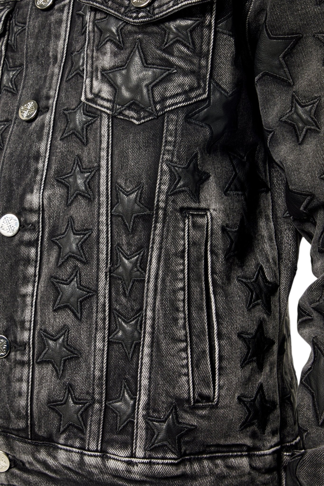 Close-up of the GUAPI Guapi Obsidian Black Stars Denim Jacket, a streetwear staple featuring embossed stars on the front and sleeves, metal buttons, and a chest pocket.