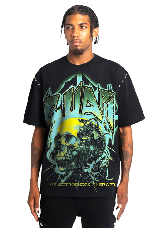 A person wears the Guapi Obsidian Blk Electroshock Therapy Tee from GUAPI, an oversized graphic T-shirt crafted from premium cotton. It features the text "SOUP" and "ELECTROSHOCK THERAPY" along with an artistic design of skulls and abstract imagery, seamlessly blending edgy style with comfort.