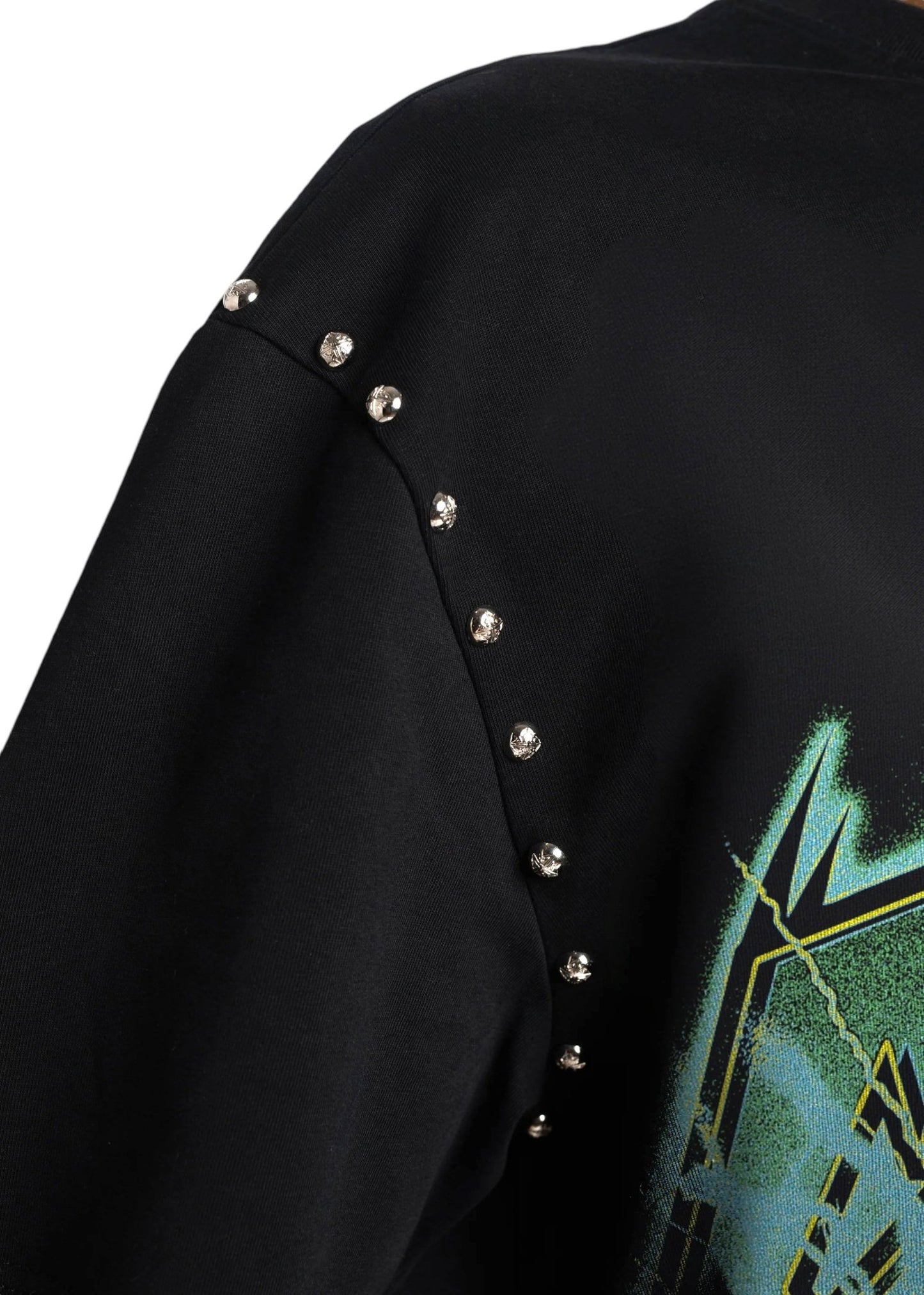 Close-up of the streetwear-inspired Guapi Obsidian Blk Electroshock Therapy Tee by GUAPI, crafted from premium cotton, with small metallic studs along the shoulder seam and a partial oversized abstract graphic in green and yellow tones.