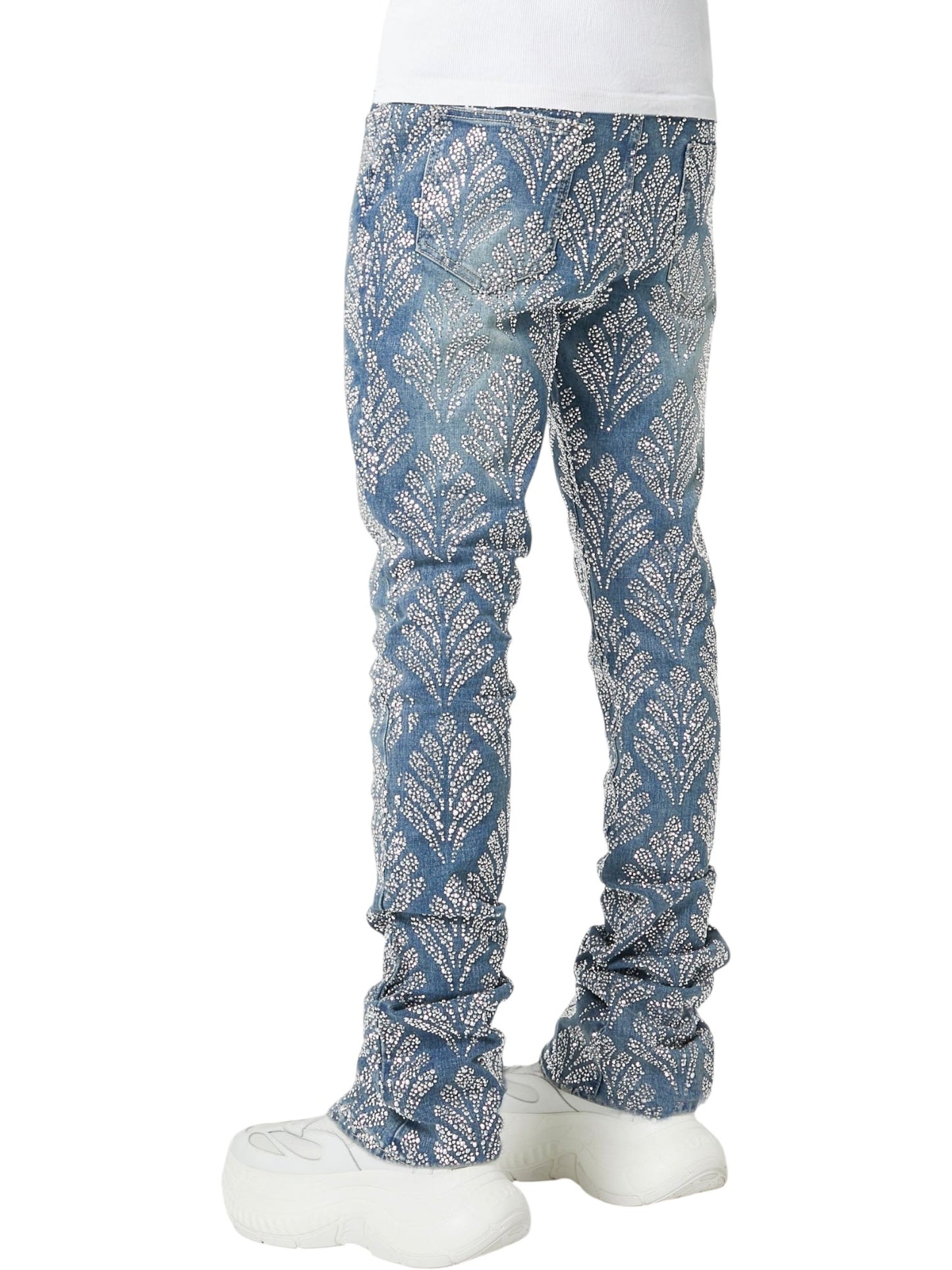 Person wearing GUAPI’s Guapi Steel Blue Embellished Denim V2 jeans, a white shirt, and white sneakers, photographed from the back.