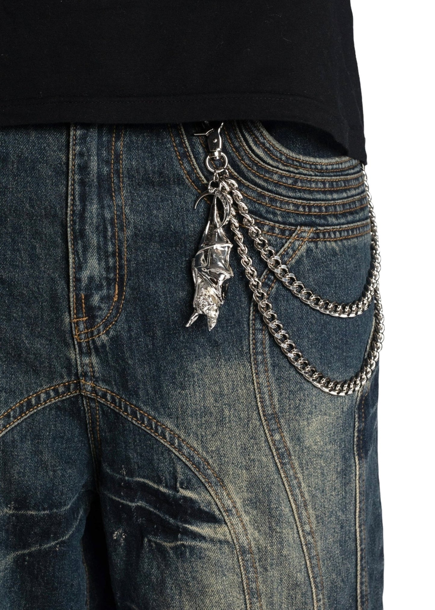 Close-up of GUAPI TEAL BLUE PIERCING SHORTS with a silver chain and keychain featuring a face design attached to the belt loop. The cotton shorts have a worn, faded look, adding to their casual vibe.