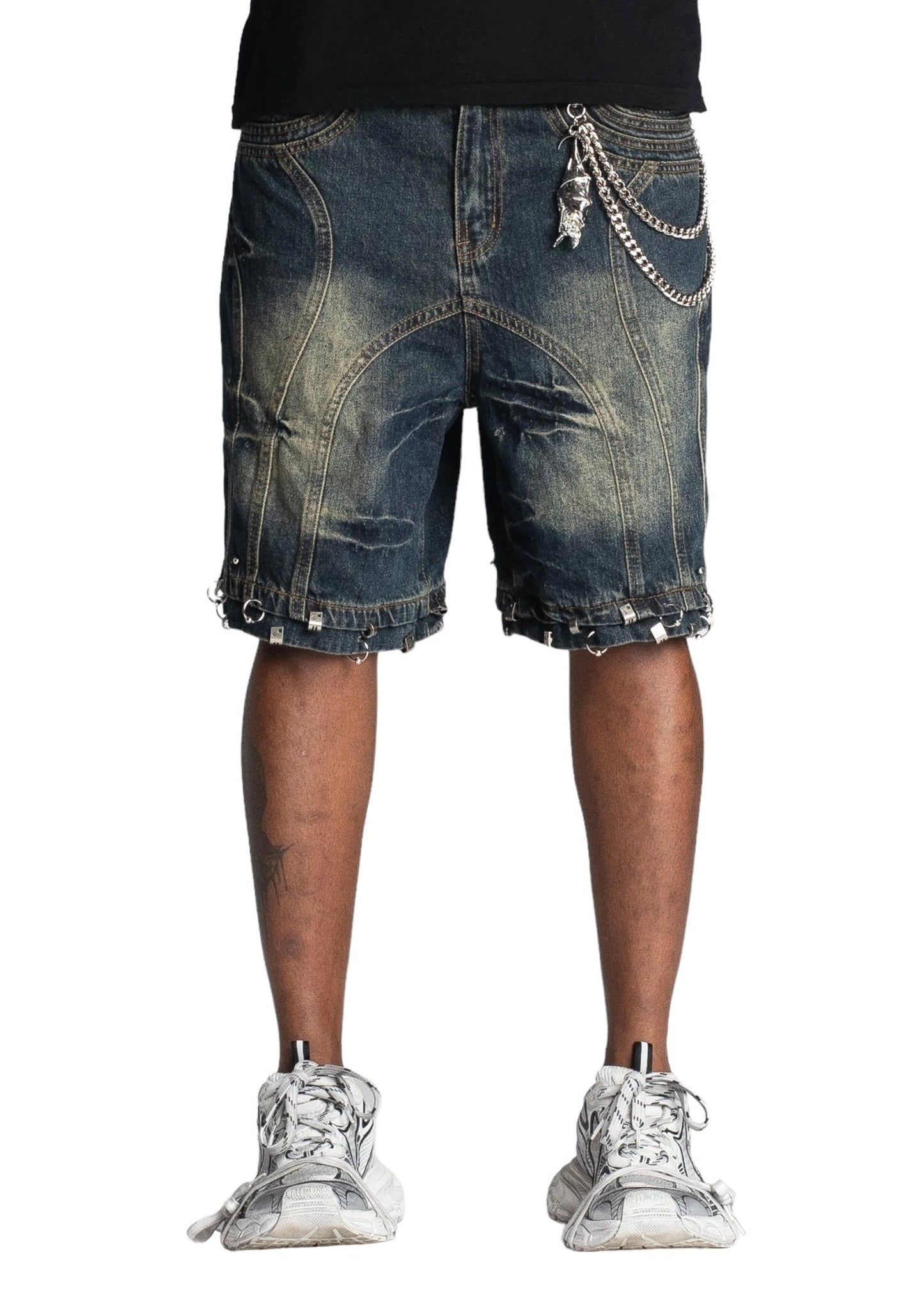 Person wearing GUAPI TEAL BLUE PIERCING SHORTS with chains and white sneakers. Only lower body visible.