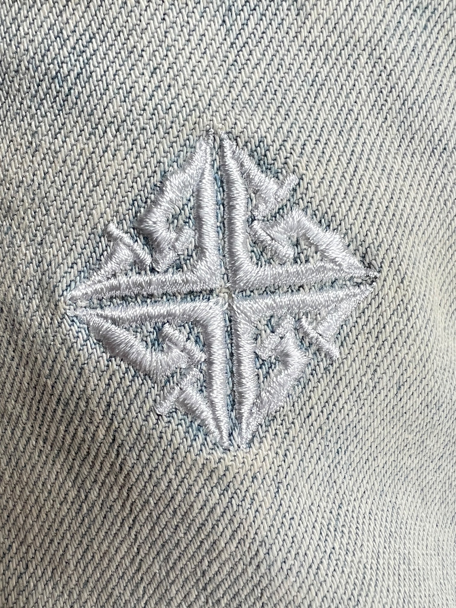 Close-up of GUAPI's Guapi Vintage Blue Basics Regular Denim V2: light vintage blue denim with a symmetrical white geometric embroidered design—ideal for fans of premium, detailed retro styles.