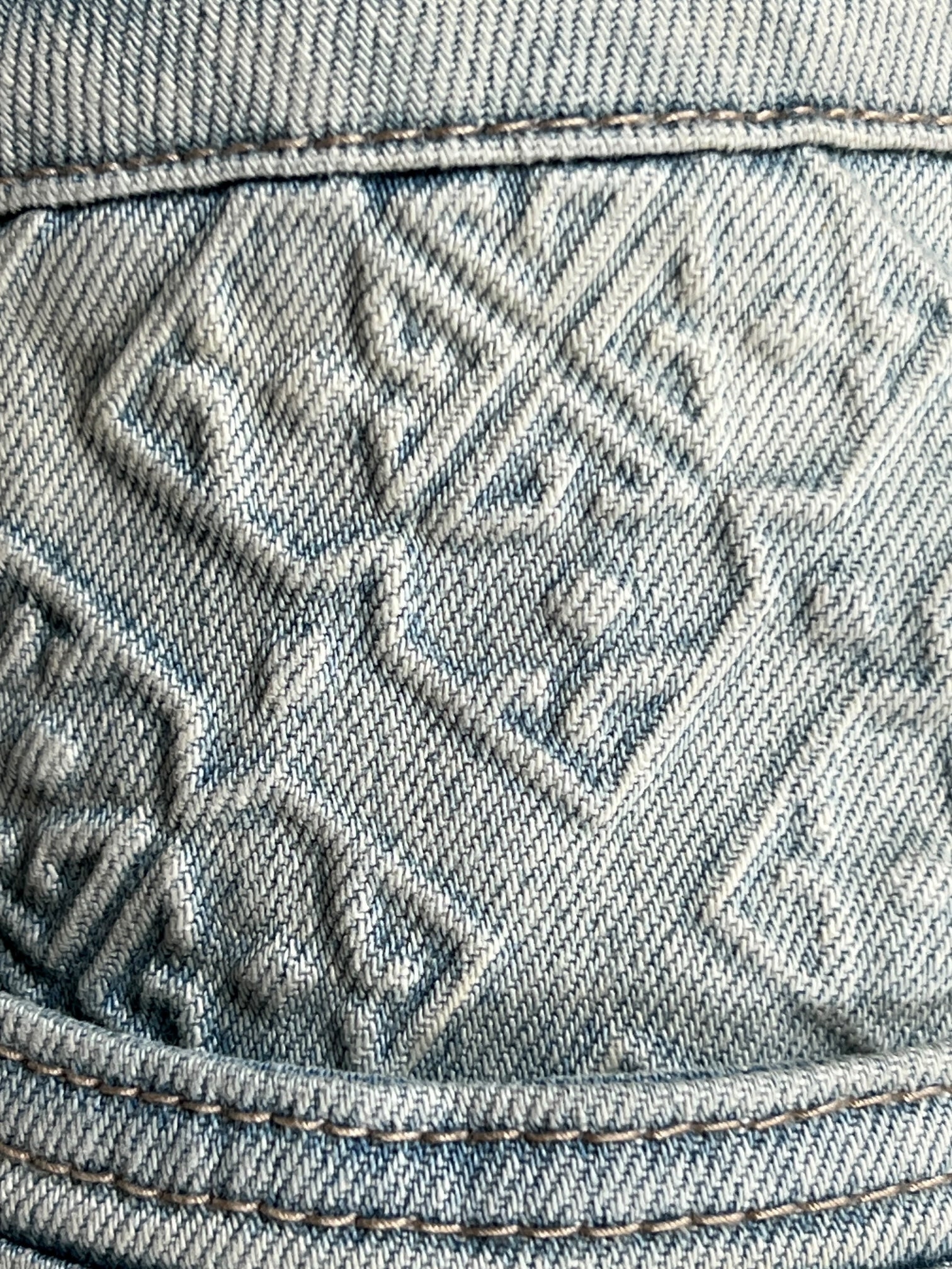 Close-up of GUAPI's Guapi Vintage Blue Basics Regular Denim V2, showcasing premium vintage blue fabric with an embossed geometric pattern and visible edge stitching.