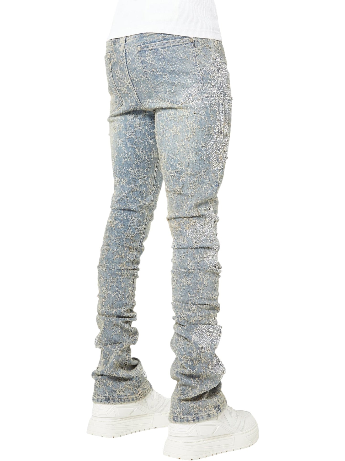 Photographed from the back, a person wears GUAPI's Guapi Vintage Blue Distressed Cross Denim jeans paired with white platform sneakers.