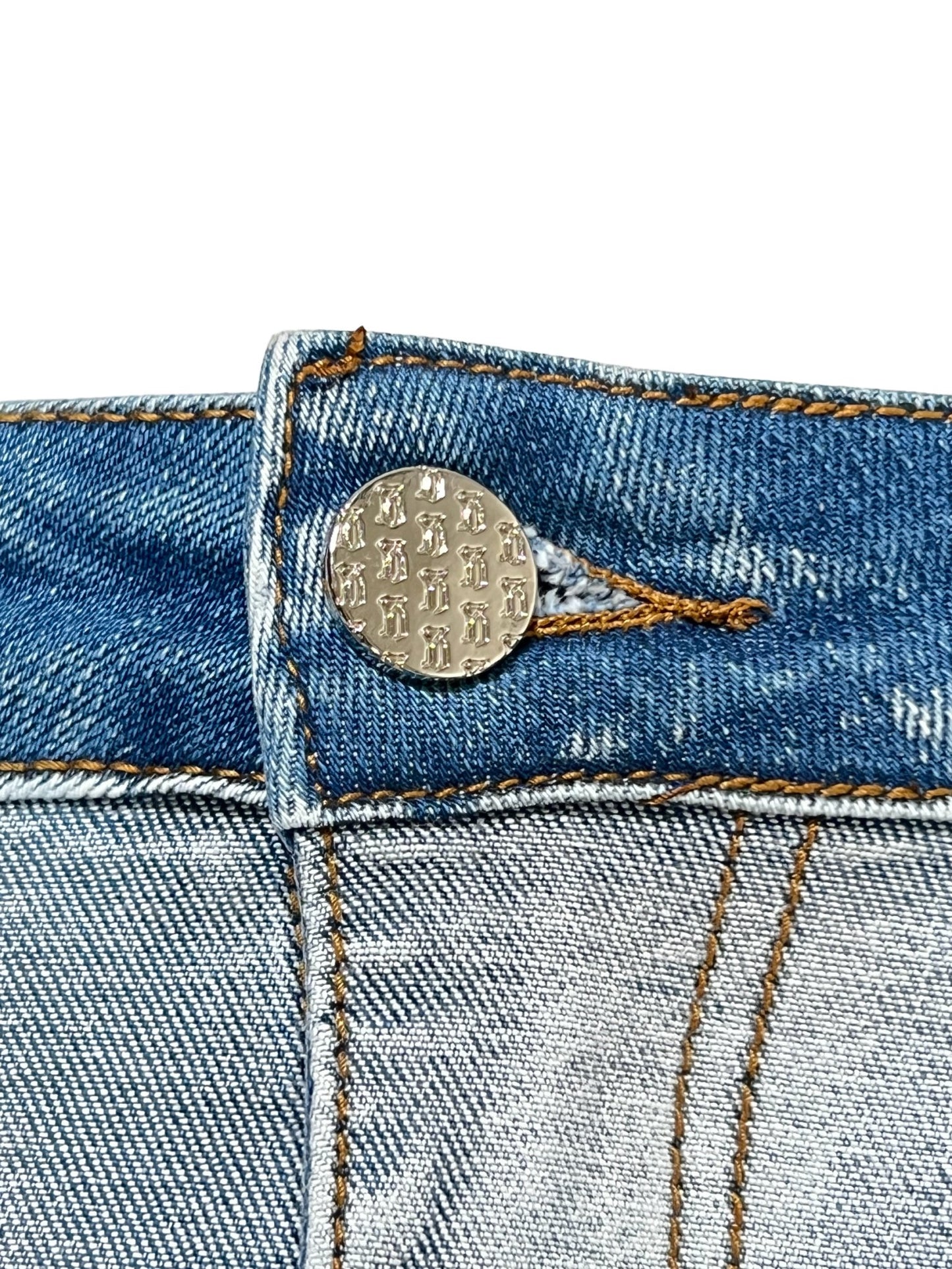 Close-up of a metal button on GUAPI VINTAGE BLUE WAVY DENIM by GUAPI.