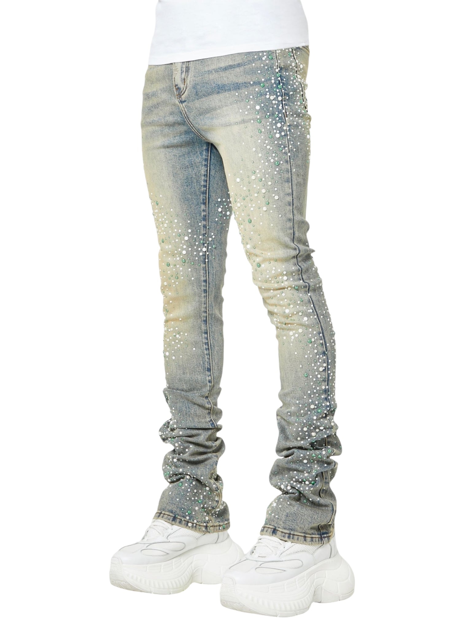 Person wearing GUAPI's Guapi Vintage Olive Pearls Denim jeans in light blue, featuring pearl embellishments, paired with white chunky sneakers; shown from shoulders down against a plain background.