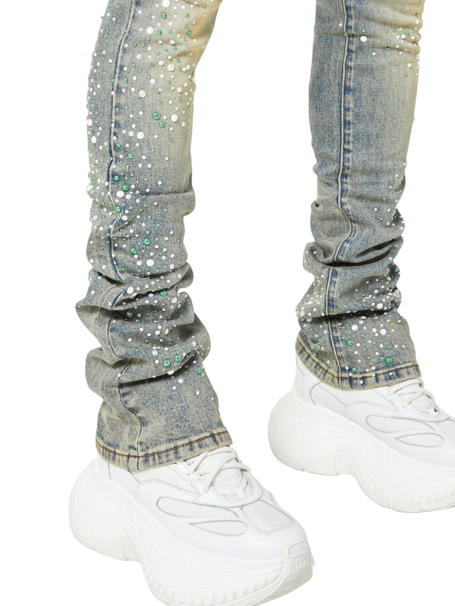 Person wearing GUAPI Vintage Olive Pearls Denim, featuring green, white, and pearl rhinestones, paired with white chunky sneakers—shown from the waist down.