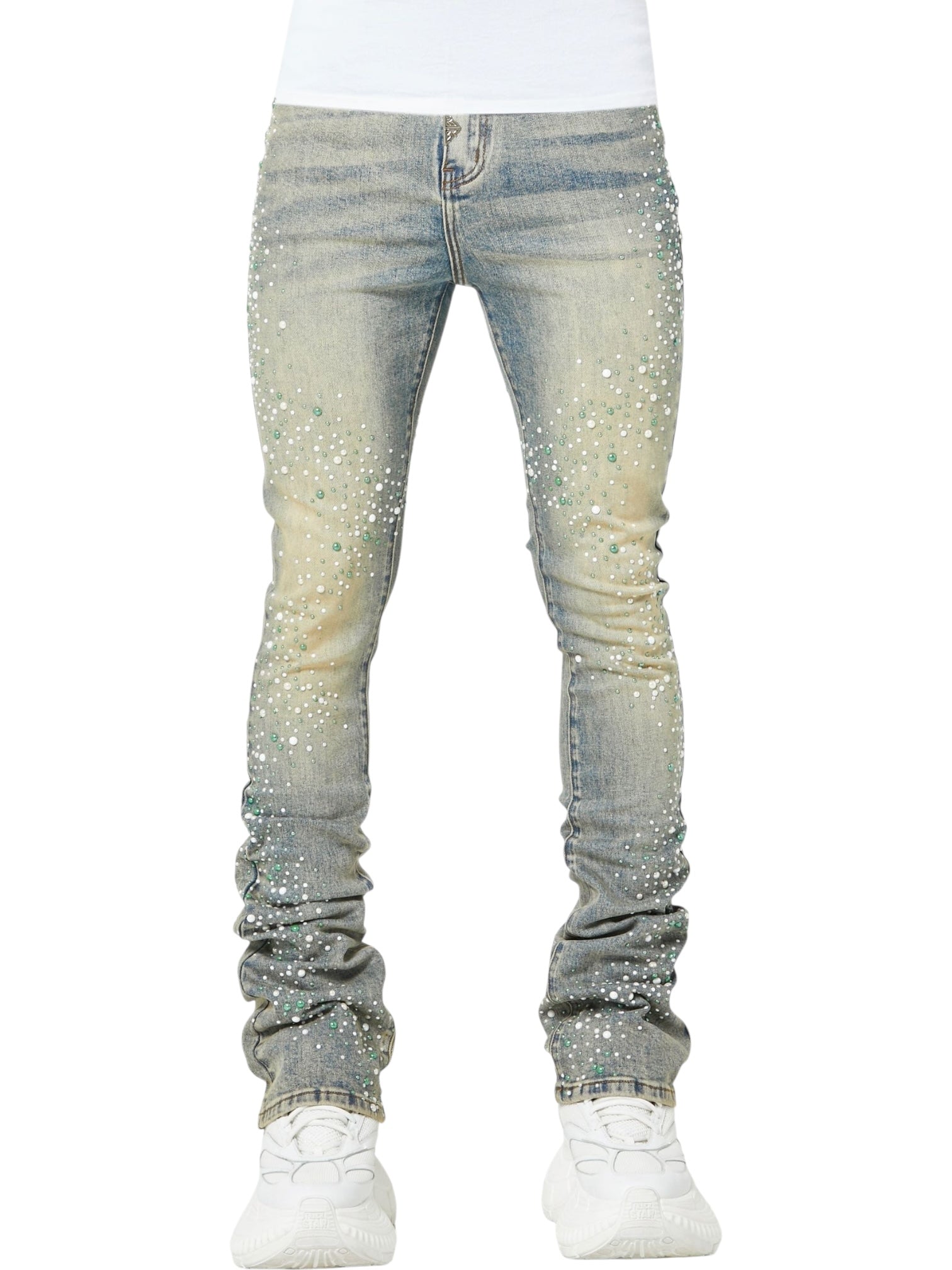 Someone wearing GUAPI's Guapi Vintage Olive Pearls Denim, featuring white and green paint splatter details, styled with white sneakers and a crisp white shirt.