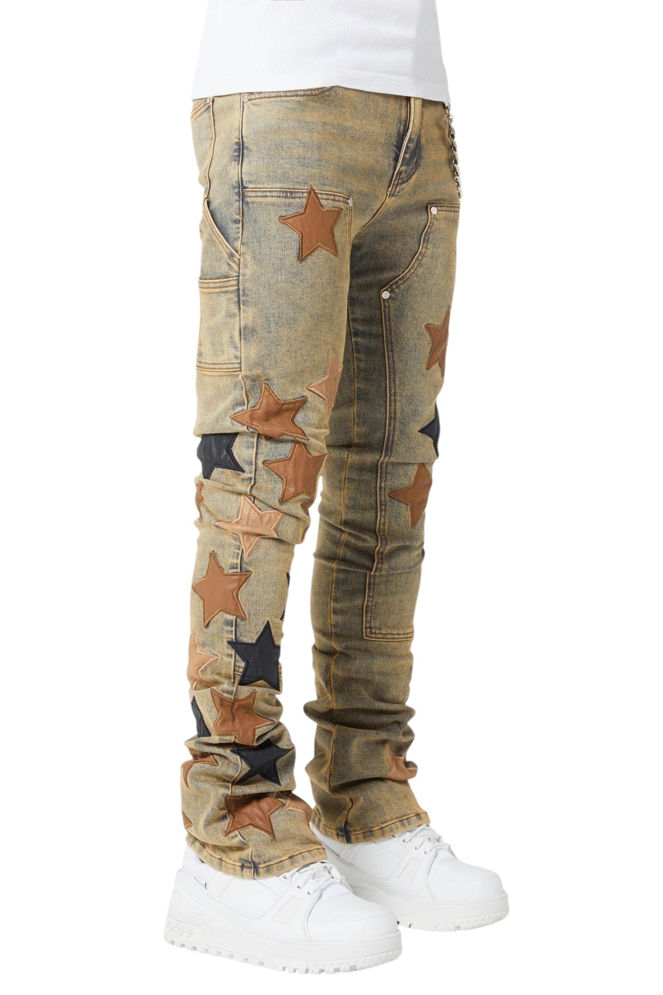 Someone is donning Guapi Vintage Stars Denim V2 jeans by GUAPI, featuring premium leather star patches, and complementing them with white sneakers.