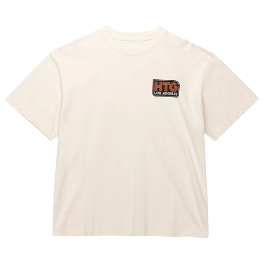 The "Honor The Gift A-Spring Htg Los Angeles Ss Tee Bone" from HONOR THE GIFT is a plain off-white T-shirt made from 100% cotton jersey, adorned with a "HTG Los Angeles" logo patch on the chest.