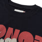 Close-up of the HONOR THE GIFT Block Party T-shirt in black, made from 100% cotton, with a sewn-in inner collar label and a bold red graphic partially visible.