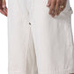 A person wears HONOR THE GIFT’s Honor The Gift Gears Carpenter Short Cream—off-white, 13" inseam, side pockets, 100% cotton—paired with a black shirt, ring, and bracelet for comfort and style.