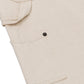 Close-up of the HONOR THE GIFT Gears Carpenter Short Cream, a beige 100% cotton short with classic twill styling, side fabric loop, black buttoned pocket, and a 13" inseam.