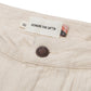Close-up of Honor The Gift Gears Carpenter Short Cream by HONOR THE GIFT, featuring a beige twill waistband, brown button, "HONOR THE GIFT®" label with size 32 tag, 13" inseam, small flag detail, and crafted from 100% cotton.