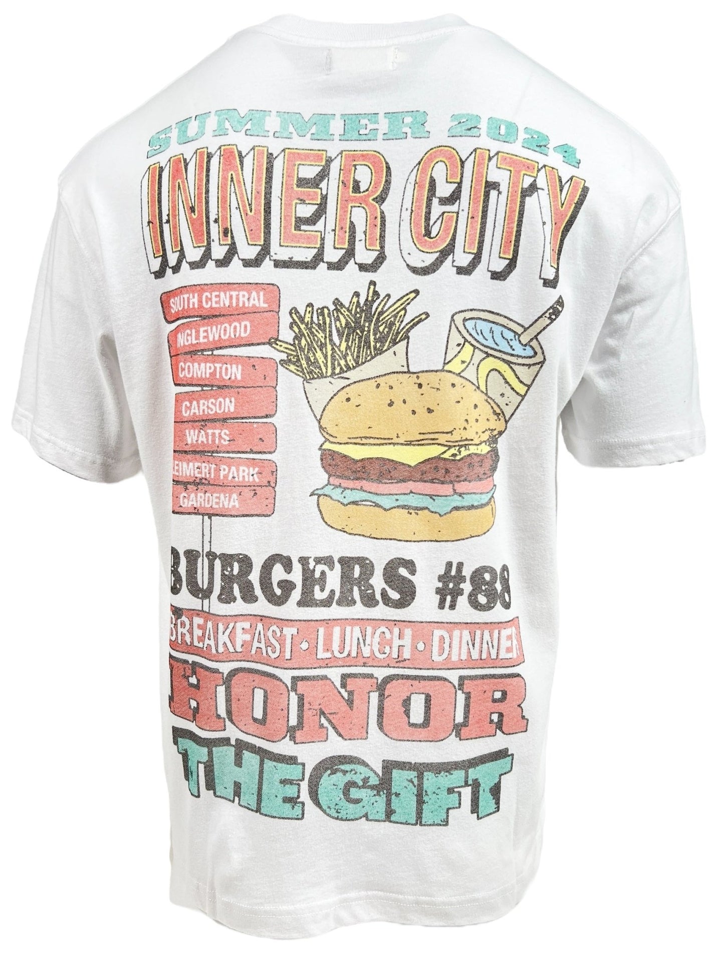 A HONOR THE GIFT HTG BURGERS SS TEE WHITE displays colorful text and graphics advertising "Inner City Burgers" with locations and meal options. The back design includes a vintage-style burger, fries, and drink under "HONOR THE GIFT.