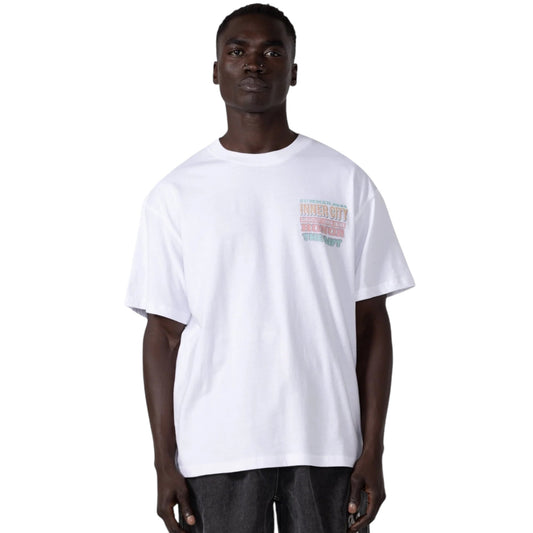 A man stands against a white background, wearing the Honor The Gift Htg Burgers Ss Tee White by HONOR THE GIFT. This plain T-shirt, made from 100% cotton and garment-dyed fabric, offers subtle character with minimalist text that seamlessly integrates into its design.