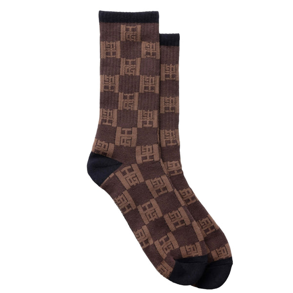 The HONOR THE GIFT MONOGRAM RIBBED SOCK BROWN by HONOR THE GIFT is a pair of brown socks with a black toe, heel, and cuff, featuring a checkered pattern with a repeated "FF" logo design. These ribbed socks also boast a reinforced footbed for added durability.