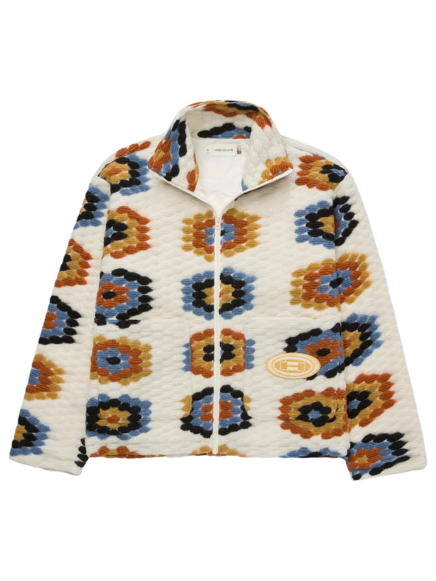 Introducing the HONOR THE GIFT TEXTURED FULL ZIP CREAM by HONOR THE GIFT—a zip-up jacket with a high collar featuring a colorful geometric pattern in shades of orange, blue, black, and beige. This festival-inspired design offers both style and warmth with its novelty textured fleece and full zip closure.