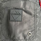 Close-up of the black polyester pocket on ICEBERG's ICE25MBS05 Short Boardshort, featuring a rubber ICEBERG patch logo, metal grommet, and repeating brand pattern. Imported.