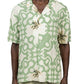 The individual is wearing the INIMIGO ISH3525 Palm Shirt Green, featuring abstract palm tree designs in a striking green and white pattern, complemented by beige pants. This versatile button-up shirt from INIMIGO adds a fresh vibe to the ensemble, making it perfect for both casual outings and relaxed summer gatherings.