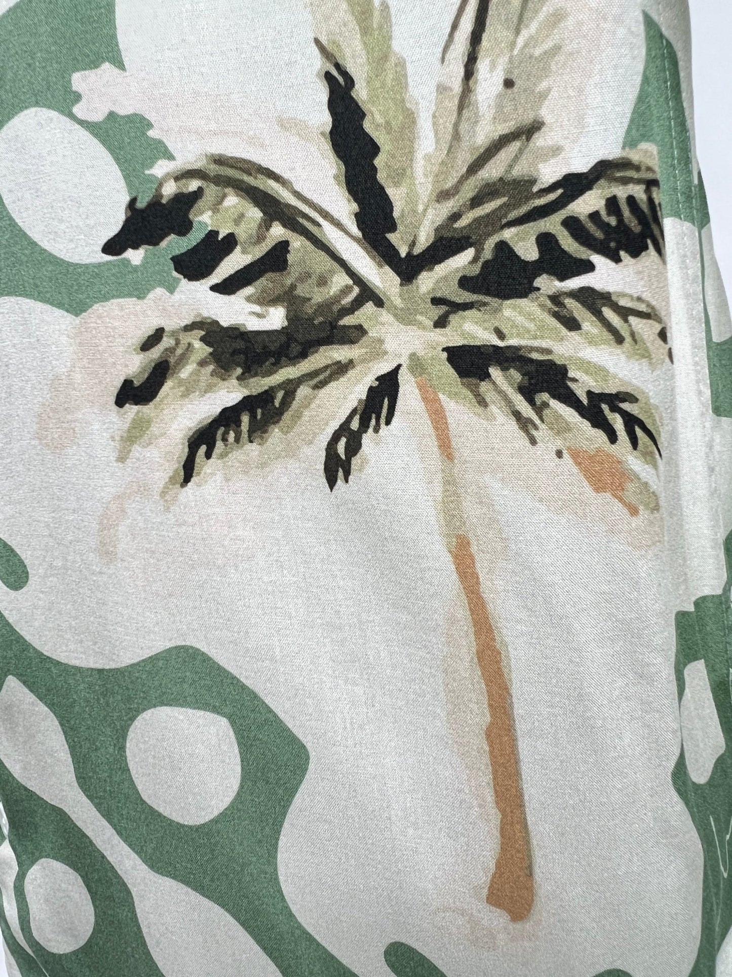 A versatile button-down fabric with a green and beige abstract pattern featuring a large palm tree print, the INIMIGO ISH3525 PALM SHIRT GREEN by INIMIGO.