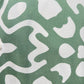 Close-up of a green fabric with a white abstract pattern and buttons along the edge, reminiscent of an INIMIGO ISH3525 PALM SHIRT GREEN by INIMIGO, perfect for any occasion.