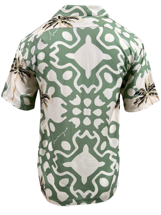 A short-sleeve shirt featuring a green and white abstract pattern with palm tree motifs, shown from the back. This versatile button-down INIMIGO ISH3525 PALM SHIRT GREEN by INIMIGO brings a touch of the tropics to any wardrobe.
