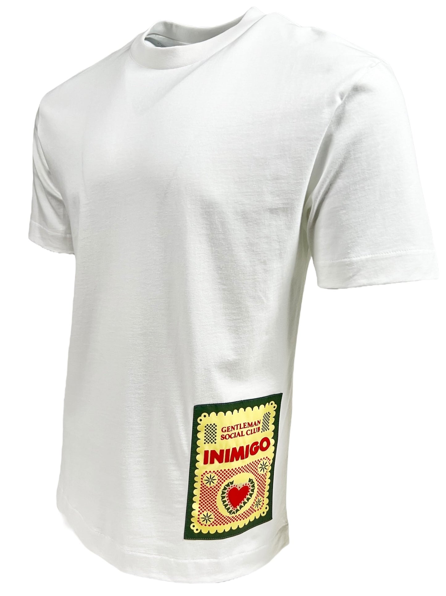 A white short-sleeve INIMIGO ITS3539 MEXICAN T-SHIRT WHITE made from 100% cotton, featuring a rectangular patch near the left hip displaying the words "Gentleman Social Club Inimigo" and a red heart symbol.