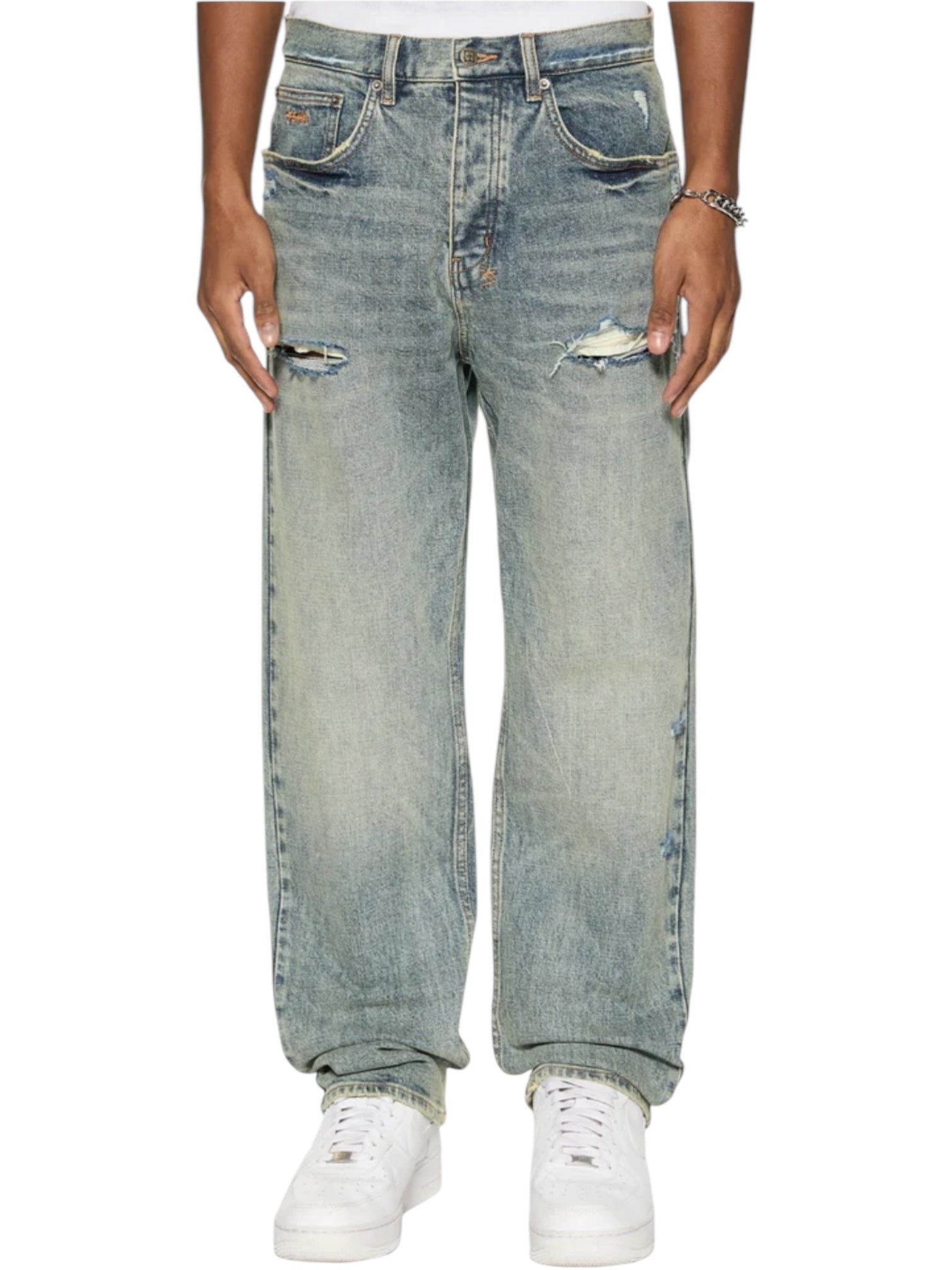 A person wears Ksubi Anti K Rogue Blue Trashed Denim with white sneakers, set against a white backdrop. The chic look is highlighted by Ksubi branded hardware for added flair.
