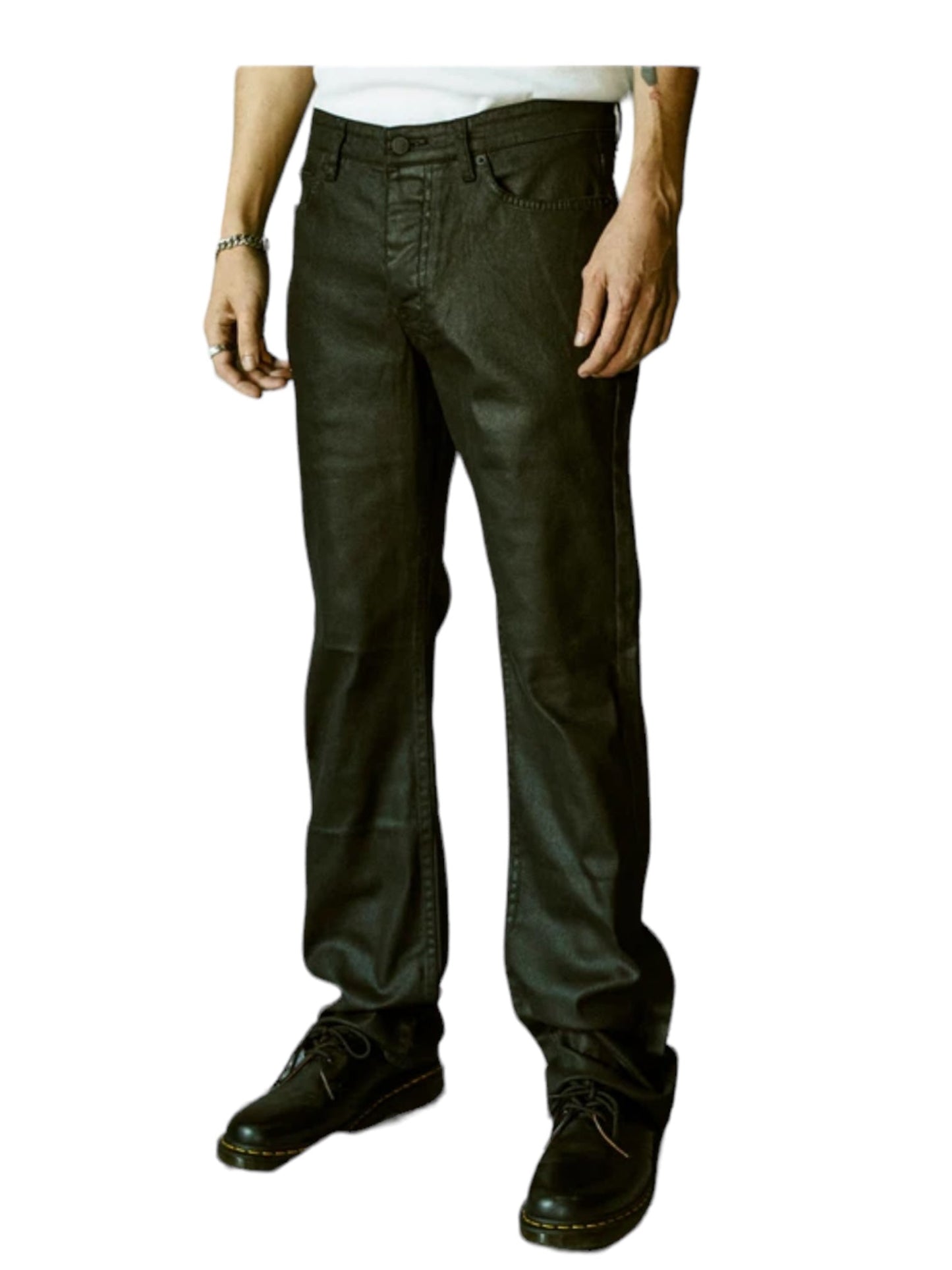 A person wearing KSUBI BRONKO BLACK WAX BLACK jeans with Ksubi branded hardware, a white shirt, black shoes, and a bracelet, standing against a white background.