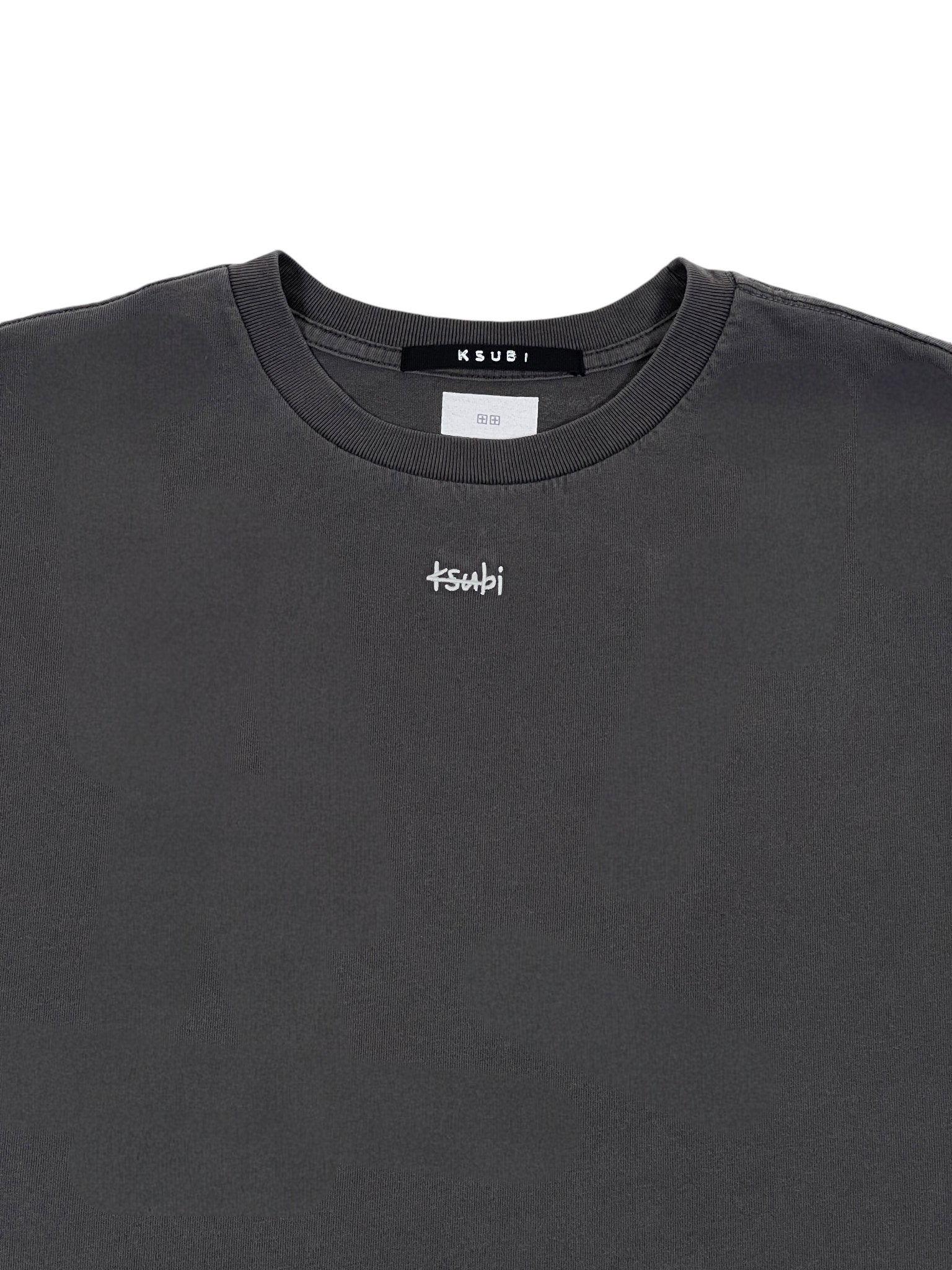 The Ksubi Eagle Biggie SS Tee in faded black is 100% cotton, featuring a small white "ksubi" logo on the chest and a black tag with white text at the neckline.