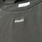 Close-up of a gray Ksubi sweatshirt, showcasing the neck label and embroidered chest logo, made from 100% cotton and echoing the understated style of the Ksubi Eagle Biggie SS Tee in faded black.