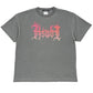 The Ksubi Fuego Ekcess SS Tee in faded black showcases a vintage style with pink and red flames spelling "RSWL" on the front, embodying Ksubi's edgy aesthetic.