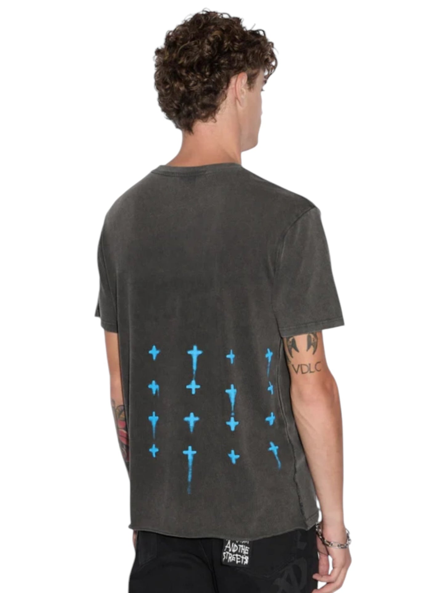 A person with curly hair wearing the Ksubi Graff Rose Kash Tee in Acid Grey from KSUBI, which features subtle blue cross patterns on the back, exudes a vintage look.