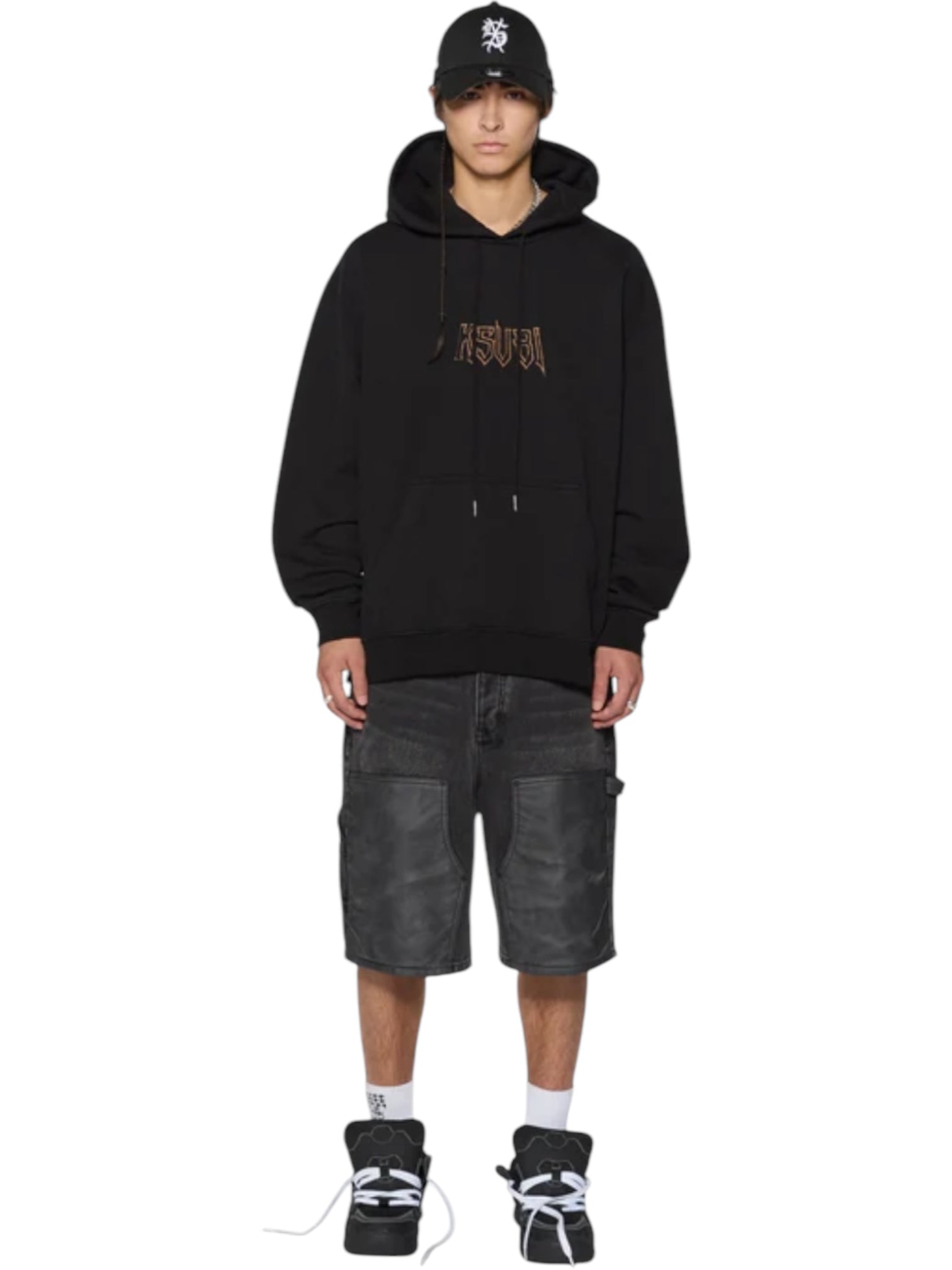 A person wears the KSUBI Kingdom Biggie Hoodie in jet black with black baggy shorts, white socks, and black sneakers, standing against a white background.