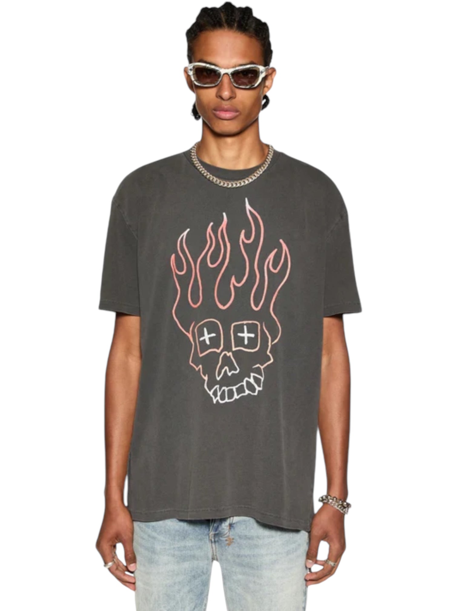 A person in a Ksubi Skull Biggie Ss Tee Faded Blk by KSUBI, oversized with a flaming skull design and premium cotton feel, accessorized with sunglasses, a chain necklace, and blue jeans stands confidently against a plain white background.
