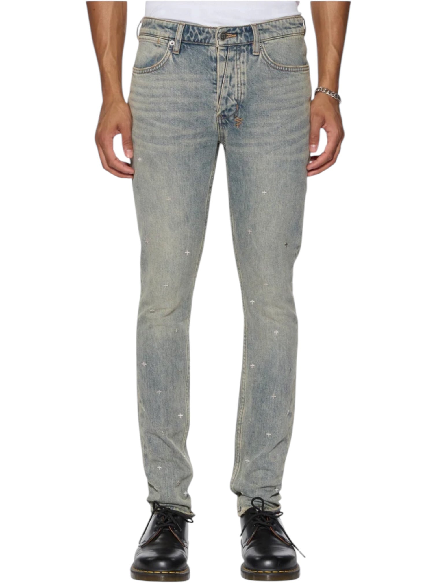 A person wearing KSUBI Van Winkle Stagelight Metalik Denim skinny jeans in light blue with subtle star details, paired with black lace-up shoes and a silver bracelet, shown from waist to feet.