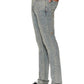 A person in KSUBI Van Winkle Stagelight Metalik Denim jeans, a white shirt, and black lace-up shoes stands in side profile against a white background.