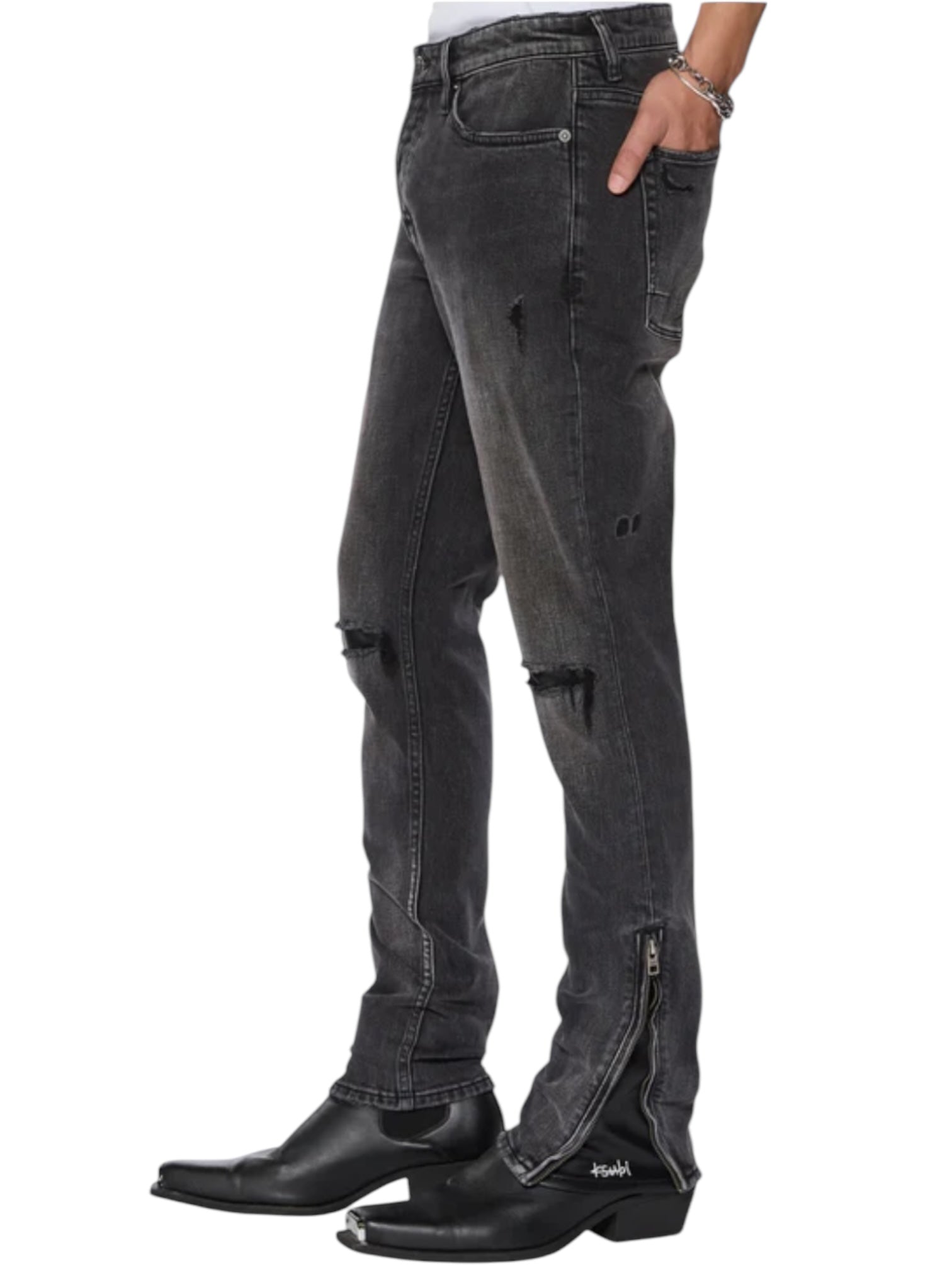 A person wearing KSUBI’s ksubi Van Winkle Torqued Chamber Black skinny jeans with zippered ankles, knee distressing, and black pointed-toe boots for premium comfort, stretch, and style.