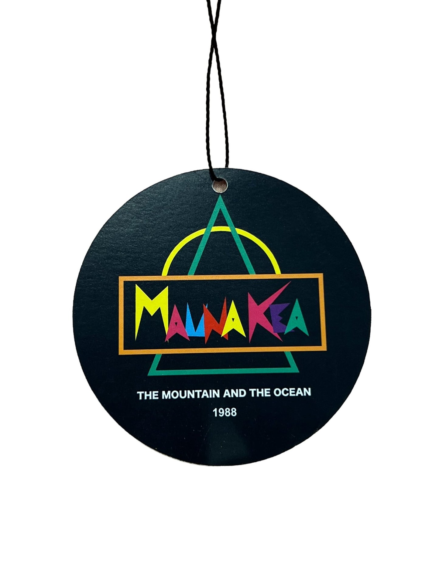 Round blue and black hanging MAUNA-KEA tag with the text "mauna kea, the mountain and the ocean, 1988" in colorful letters, and an abstract geometric design featuring a graphic roses print above.