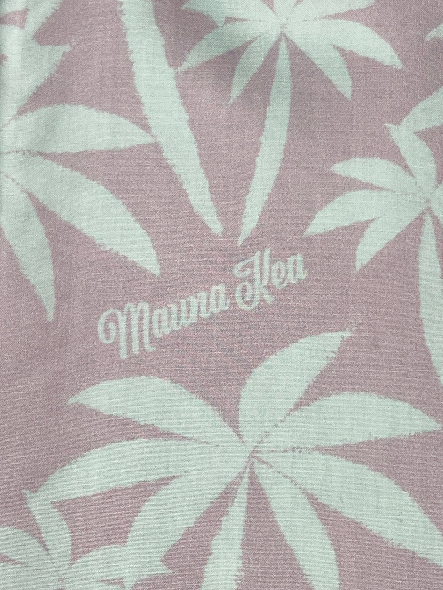 This short sleeve shirt, named the Mauna-Kea Mku142-Pm3 Allover Print Shirt Pink by MAUNA-KEA, is adorned with textured fabric showcasing a white palm leaf pattern and elegantly features the words "Mauna Kea" printed in the center.