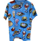 The Moschino 0718-Cotton Jersey Fantasy Print Light Blue t-shirt features a fun print of burgers, fries, ice cream, and salads on a white hanger. Made in Italy, it's perfect for fashion lovers with a playful side.