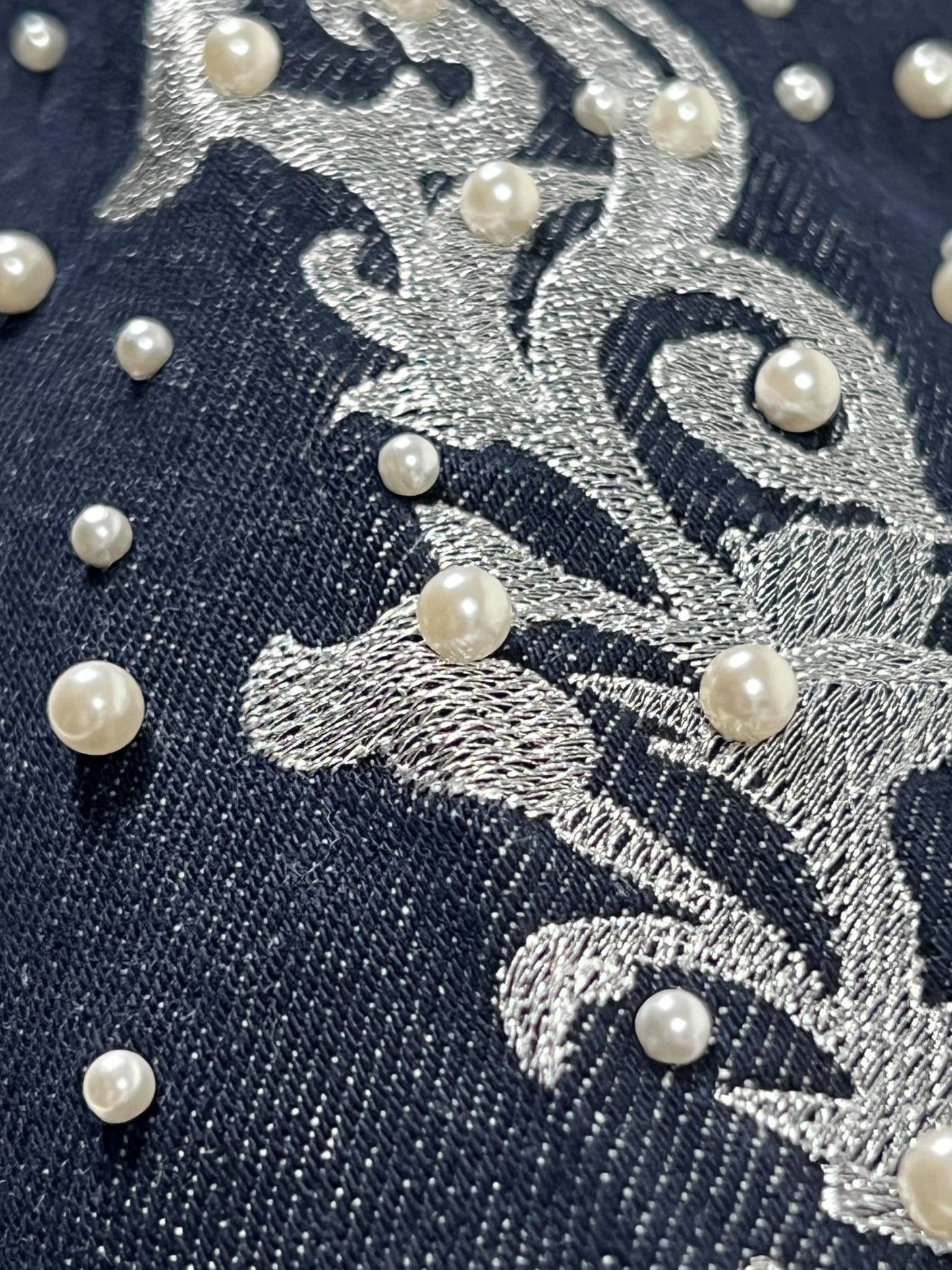 Close-up of pearl embroidery and silver stitching on the Only The Blind BC25SSPT22 Raw Pearl Flared Jeans Blue by BIRTH OF ROYAL CHILD.