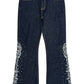 The BIRTH OF ROYAL CHILD Only The Blind BC25SSPT22 Raw Pearl Flared Jeans Blue feature dark blue raw denim, white embroidery, and silver studs on the lower outer sides of each leg.