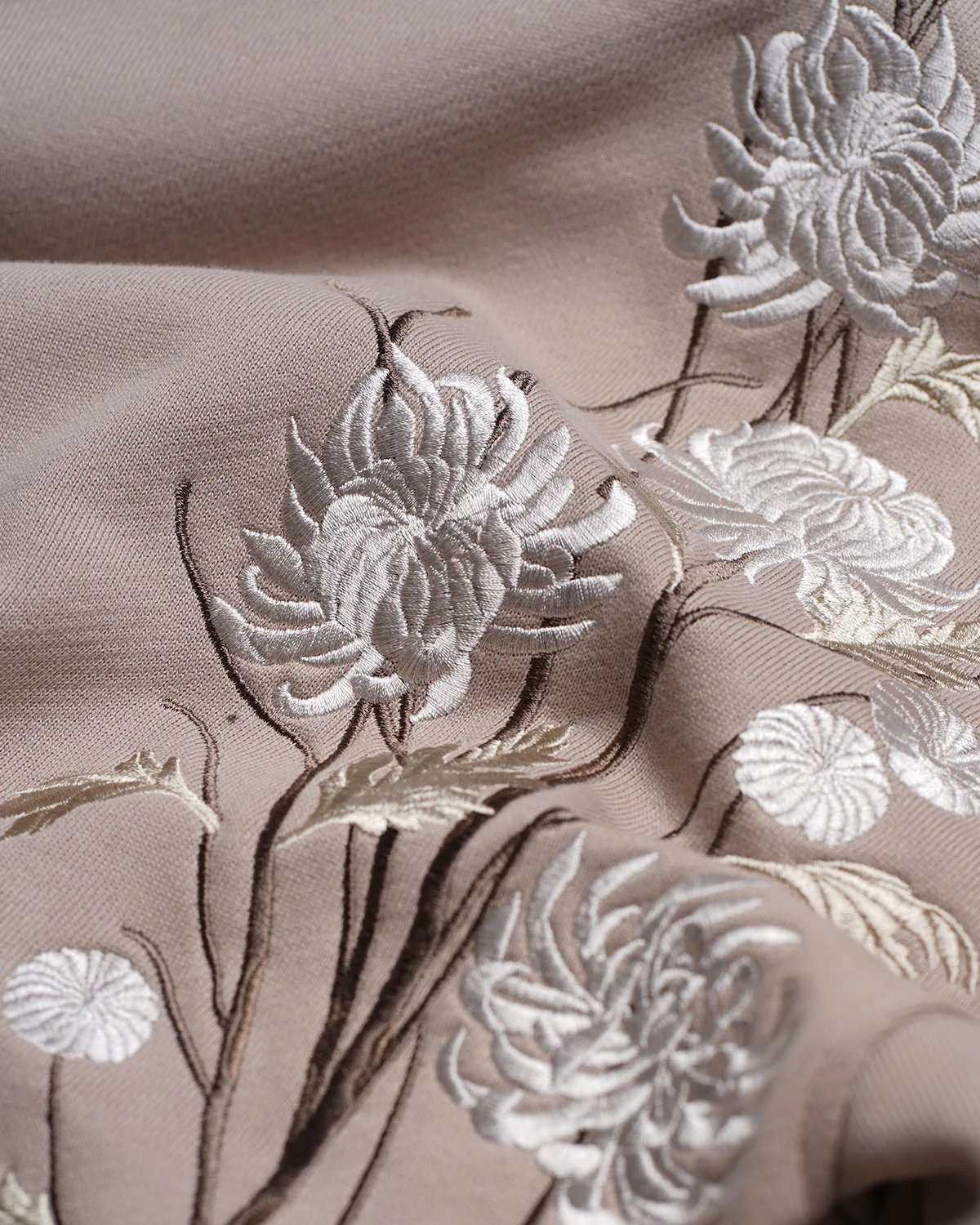 Close-up of the Only The Blind OTB-H1033 Ogiku Embroidered Hood by ONLY THE BLIND, showcasing its intricate white embroidered blossom design with a textured surface.