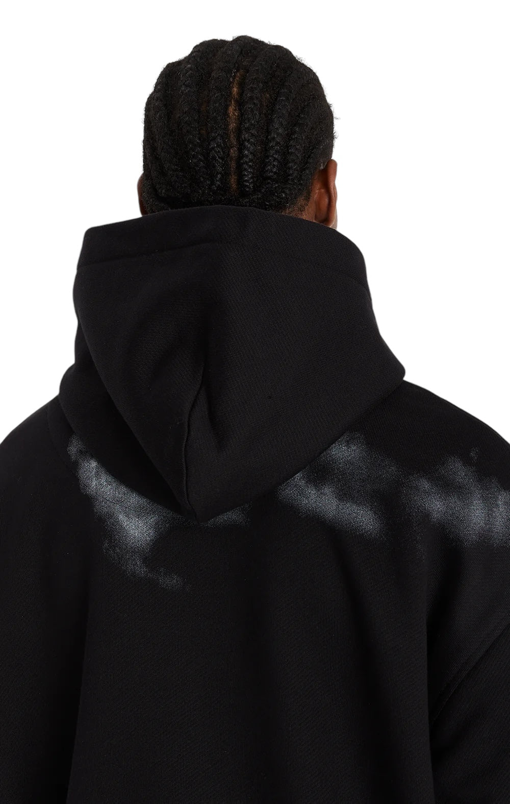 A person with braided hair wears the Only The Blind OTB-H1355 Midnight Hawk Hoodie Blk, made from GOTS® Certified Organic Cotton, featuring a black color and white paint splatter on the shoulders.