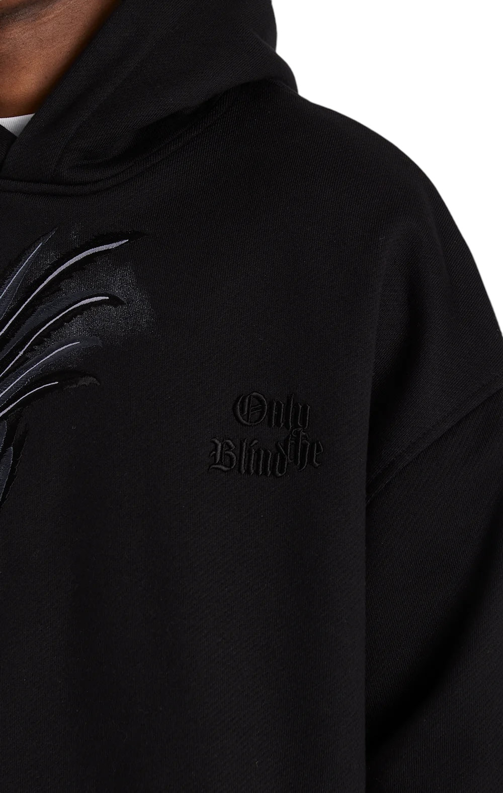 Close-up of the ONLY THE BLIND OTB-H1355 Midnight Hawk Hoodie in black, showcasing dark text and an intricate claw design on the left side, crafted from GOTS® Certified Organic Cotton for superior comfort and sustainability.